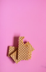 Waffles on a smooth pink background. perfect for illustrating a minimalist breakfast or dessert idea.