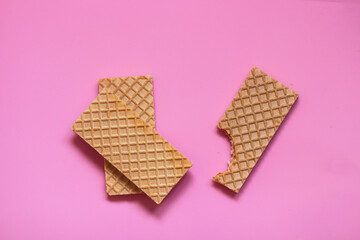 Waffles on a smooth pink background. perfect for illustrating a minimalist breakfast or dessert idea.
