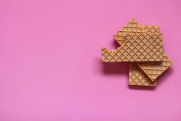 Waffles on a smooth pink background. perfect for illustrating a minimalist breakfast or dessert idea.