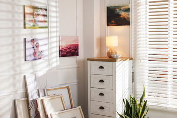 Canvas with different printed photos on wall indoors
