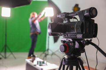 Man working in modern film studio, focus on camera