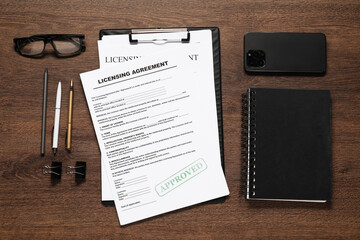 Flat lay composition with licensing agreement documents on wooden table