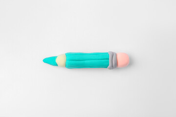 Pencil made from play dough on light grey background, top view