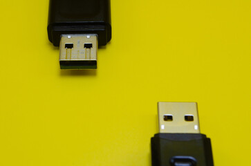 Two USB connectors, a micro and a standard, rest on a vibrant yellow background, showcasing simple...