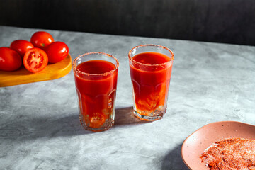 Two refreshing vegetable cocktails. Red cocktail. Tomato juice served in glass with tomato slice. Image for menu, bars, restaurants