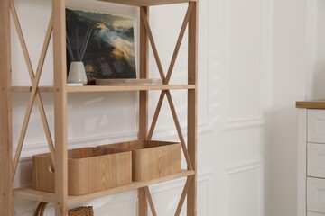 Stylish shelving unit with decor near white wall indoors