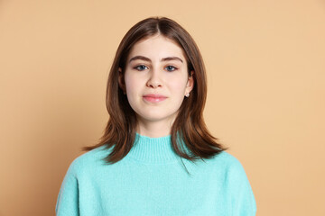 Fototapeta premium Portrait of beautiful teenage girl on beige background