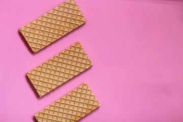 Waffles on a smooth pink background. perfect for illustrating a minimalist breakfast or dessert idea.