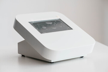Fototapeta premium Modern Minimalistic White Digital Device with Water Droplets on Screen Display