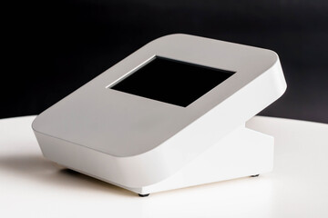 Modern White Electronic Device with Touchscreen Display on White Surface Against Dark Background