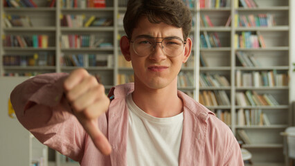 Caucasian teen boy upset dissatisfied frown student guy male pupil man teenager in glasses showing...