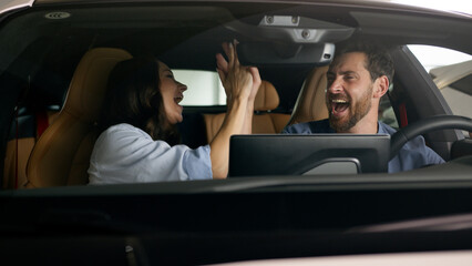 Caucasian couple dancing happy inside automobile celebrate buying auto joyful driving trip travel dance give high five fun man guy male boyfriend husband in car with woman girl female girlfriend wife