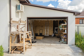 Open garage with tools and wooden planks. Organized storage and efficient use of residential...