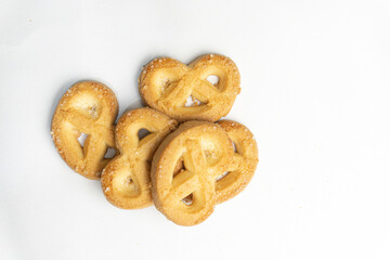 A cluster of delectable butter cookies presented against a clean white canvas, highlighting their sugary coating and intricate shape.