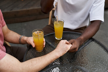 Loving couple enjoys intimate moment over drinks at vibrant cafe during sunny afternoon