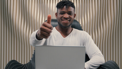 Smiling African American man guy male hacker e-business typing keyboard laptop futuristic cybersecurity coding business online crypto blockchain digital metaverse technology showing thumb up