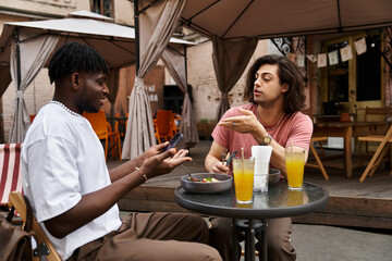 Loving gay couple enjoys a delightful date at a cozy cafe on a sunny afternoon