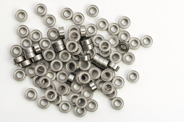 Miniature ball bearings pile on white background for industrial and precision applications