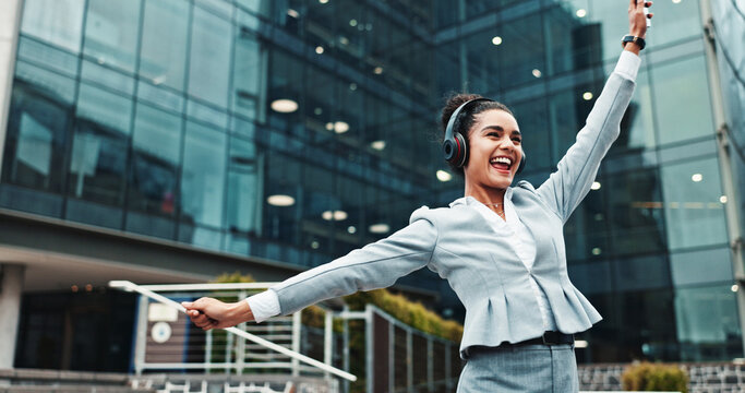 Business, woman and dancing with headphones in city for music playlist, celebration and streaming audio. Excited, person and energy outdoor for sound subscription, listening to radio and work break