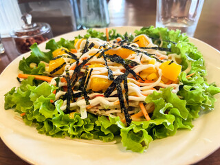 Kani salad with crab, fresh lettuce and mango with vegetables on a plate