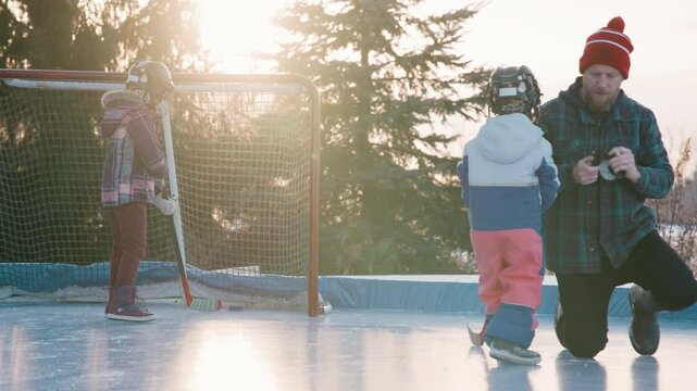 Dad with his girls on the hockey rink