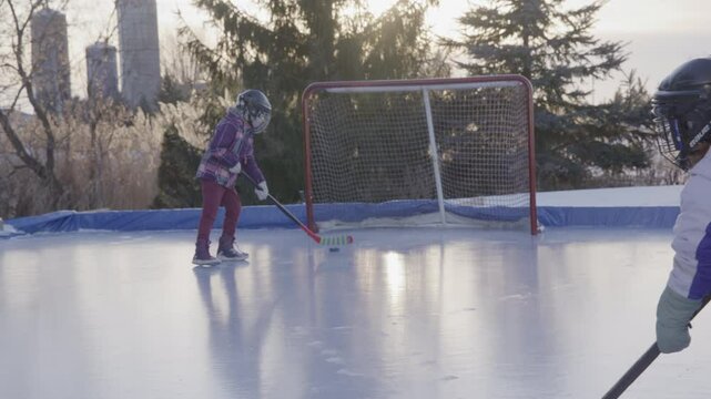 sisters playing hockey on the ice together in boots