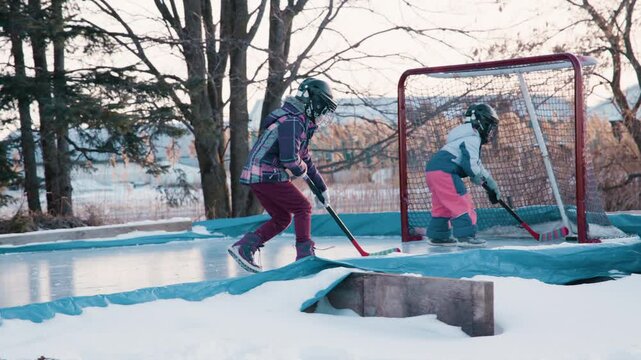 Sisters rushing the net on hockey rink