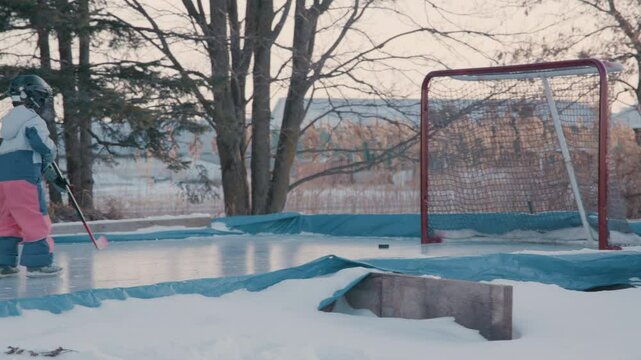 Child taking a shot at the hockey net