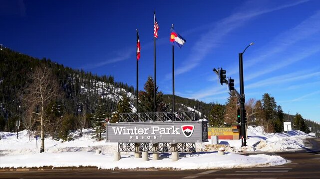 Winter Park Ski Resort early morning December blue sky fresh snow center village entrance still static shot gondola Colorado flags Mary Jane Ski Resort sunny beautiful Rocky Mountain winter day