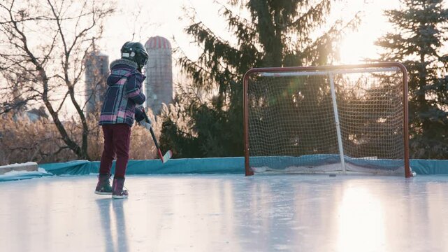 Little girl scores a goal on hockey net