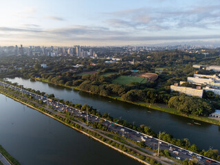 Fototapeta premium Rising sun on a river within the metropolis of São Paulo with the Pinheiros riverside.