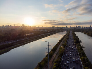 Rising sun on a river within the metropolis of São Paulo with the Pinheiros riverside.