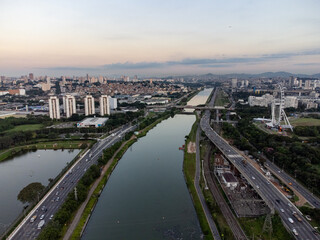 Obraz premium Rising sun on a river within the metropolis of São Paulo with the Pinheiros riverside.