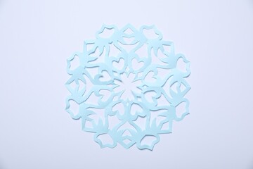 One paper snowflake on white background, top view