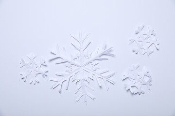 Beautiful paper snowflakes on white background, flat lay