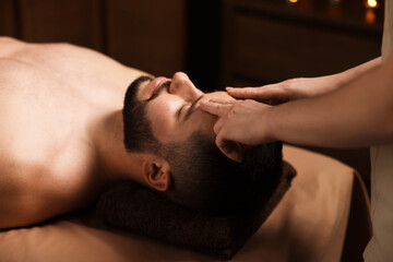 Man receiving relaxing massage in spa salon