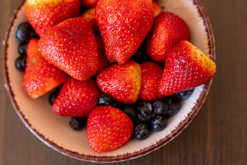 Berries on a wooden background. Strawberries and blueberries. Top view