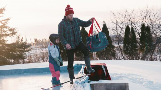 Dad with daugher putting skates on.