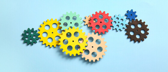 Wooden gears on light blue background
