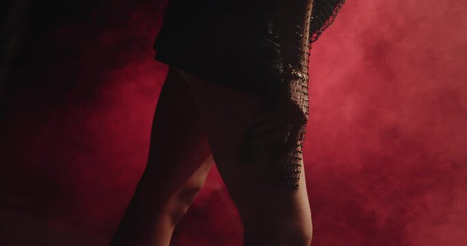 Beautiful woman posing, touching herself on the ankle in slow motion close up