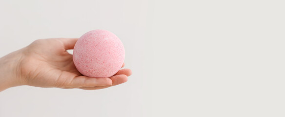 Woman with pink bath bomb on light background