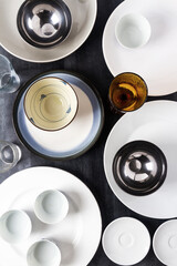 Top view of an empty plates, bowls and glasses placed on a black chalkboard background. Flat lay. Top view. Food concept.