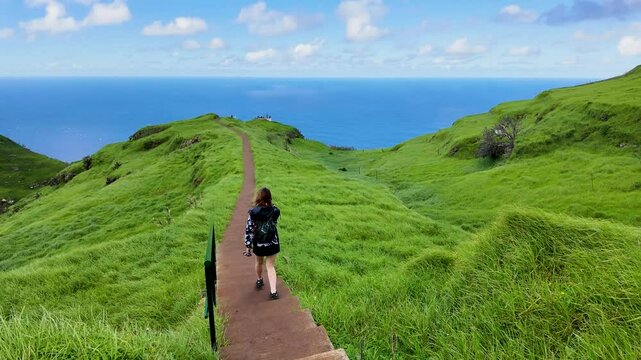 Girl Walking Along Clifftop Path with Tall Green Grass at Ponta do Pargo, Boa Morte, Madeira