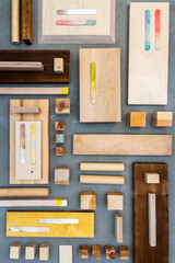 Flat lay of various wood and plywood pieces on concrete texture. Carpentry background.