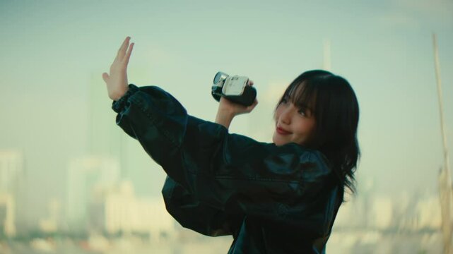 young female filmmaker recording with old retro camera recorder the urban cityscape