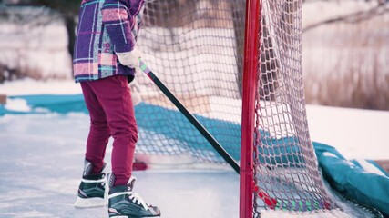Female hockey player outside in the net - Powered by Adobe