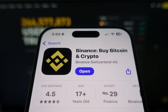 Kiel, SH, Germany March 27 2025: Binance app by Binance Switzerland AG in the App Store on smartphone screen with company website visible in background