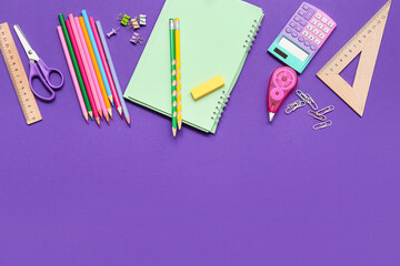 Notebook, correction tape and scissors on purple background. Top view