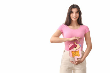 Young woman with paper digestive system on white background