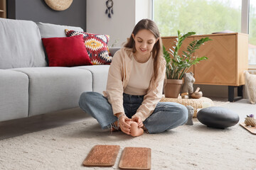 Young woman after standing on Sadhu board sitting at home